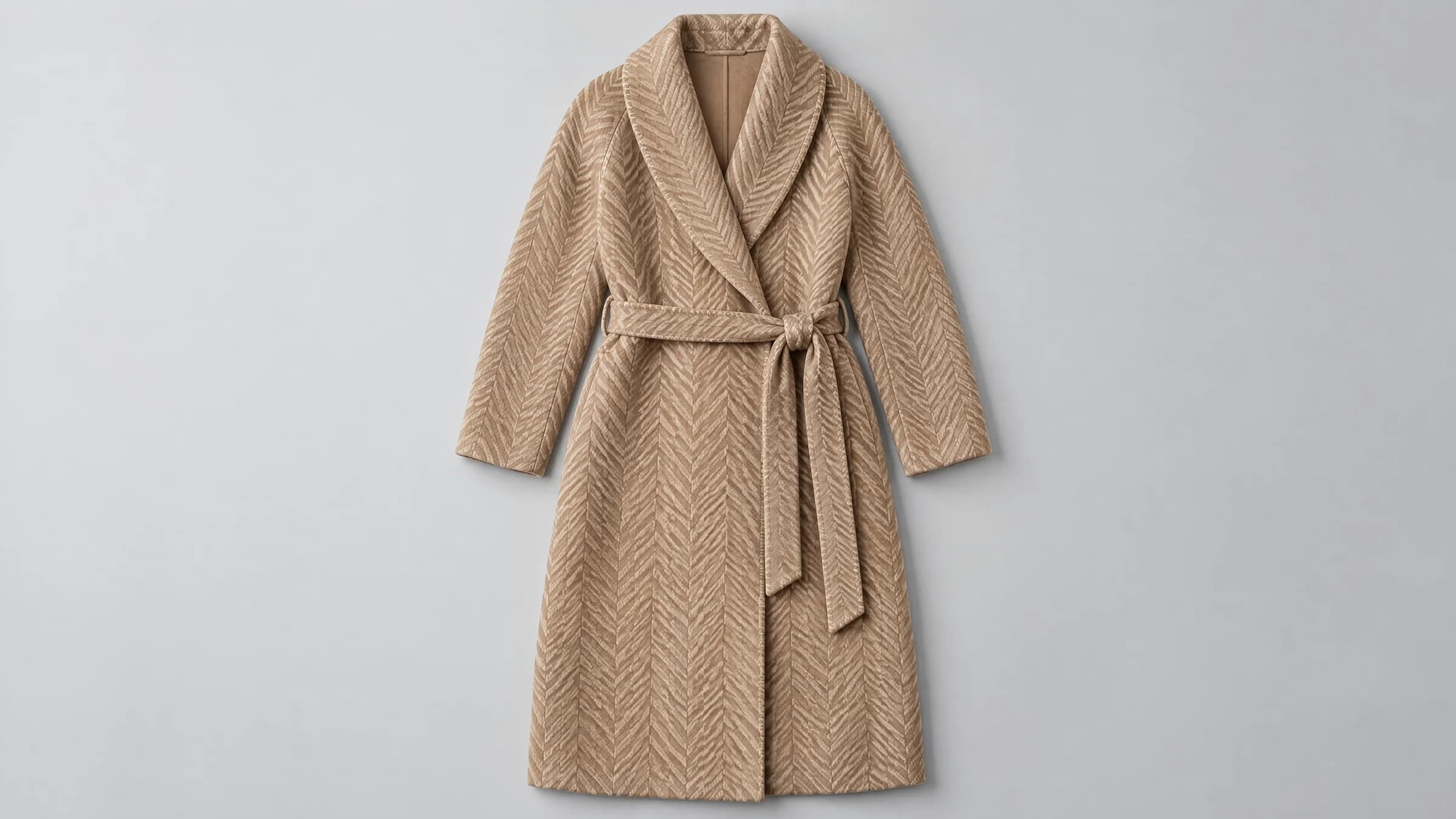 Camel herringbone coat with shawl collar and belt, laid flat on a light grey background