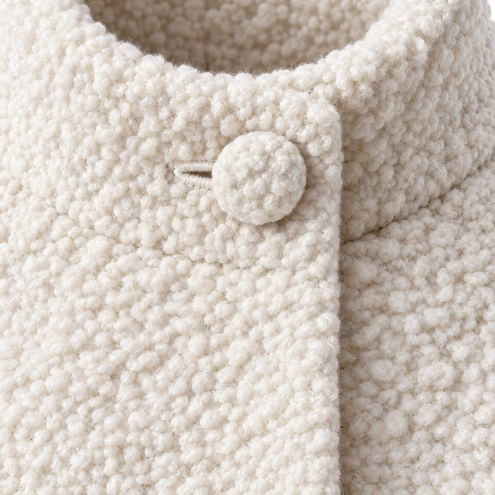 Close-up van ecru bouclé met een beklede knoop